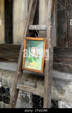 Old framed painting displayed on an old wooden step ladder at a Flea Market, Brocante, Place Sainte Catherine, Honfleur, Normandy, France Stock Photo