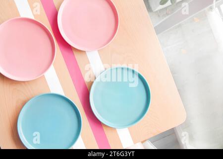 Colourful empty plates on a wooden table at a coffee shop. Stock Photo