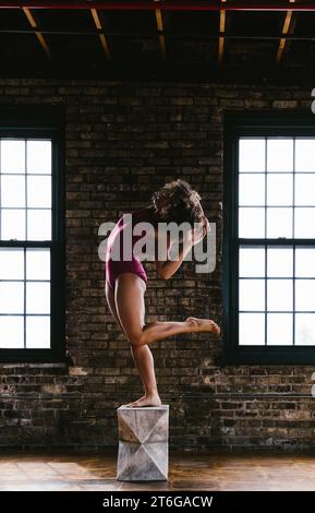Woman dancer poses with legs and arms in body figure Stock Photo