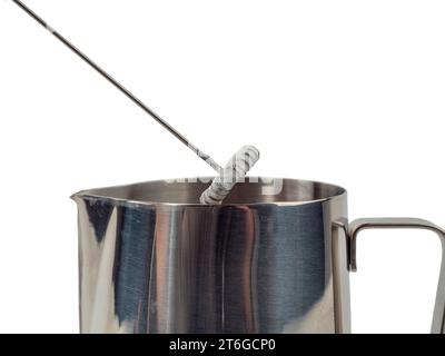Automatic milk foam maker. Metal milk mug and electric milk frother isolated on a white background. Stock Photo