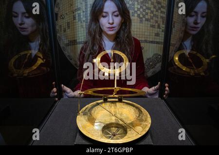 London, UK.  10 November 2023. A staff member views a 17th-century Safavid brass Mecca Centred World Map, (Est. £1,500,000-2,000,000) at a preview of Bonhams Islamic and Indian Art sales.  Lots will be auctioned at Bonhams New Bond Street galleries on 14 November.  Credit: Stephen Chung / Alamy Live News Stock Photo