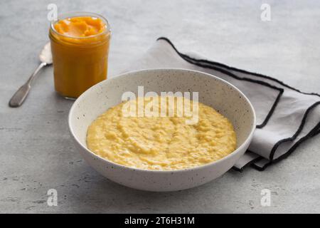 Bowl of oatmeal with pumpkin on a gray textured background. Delicious healthy homemade breakfast Stock Photo