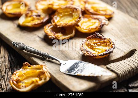 Mini tarts made of puff pastry and sliced apples on a cutting board. France apple cakes - Close up. Stock Photo