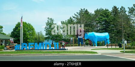 BEMIDJI, MN – 3 JUN 2023: Statue of Paul Bunyan and Babe the Blue Ox, a popular roadside attraction and blue sign along the street. Stock Photo