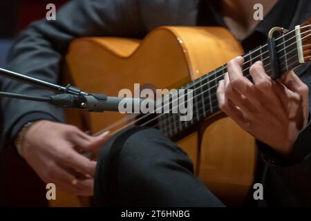 The singer plays an acoustic guitar. Close up of man's hands playing acoustic guitar. Musical instrument for recreation or hobby passion concept. Posi Stock Photo