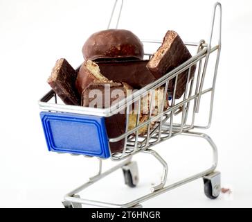 Pieces chocolate cubes ,shopping cart on white background, close-up view Stock Photo