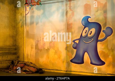 China, Shanghai, a homeless man sleeps on the street under a picture of the expo mascot haibao Stock Photo