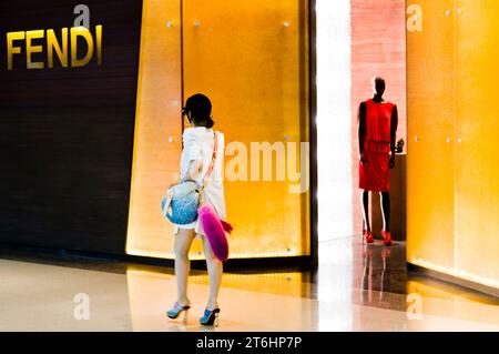 China, Shanghai, Mall Plaza 66 in Nanjing Lu, Chinese woman walks past fashion boutique with mannequin Stock Photo
