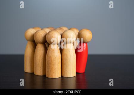 A man leans away from the crowd. Staff reduction. Excluded from the team. Conflict, toxic social environment. Work optimization. Outsider, outcast. Re Stock Photo