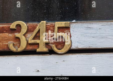 Numbers. Golden color. Detail. Old house glass door frame. 345. Learn to count, concept. Mathematical symbols. Odd and even number. Stock Photo