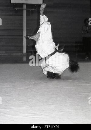 1970s, judo, two male competitors locked together in combat on a mat, both of them upside them down, feet up, England, UK. The Japanese martial art of Judo is a tough physical sport, involving numerous moves, but one which also demands strong mental discipline, concentration and resilience. A key factor in judo is one of respect, for your opponent and yourself. Stock Photo