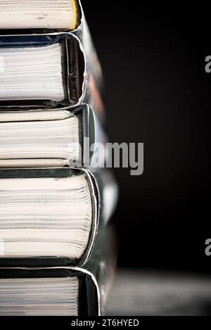 Close-up of hardbound books stacked on a black table Stock Photo