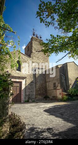 The church of Saint Martin in Aigne was built in the XI century in Roman style and is equipped with 3 Gothic bells. The old village center has the shape of a snail shell and was also built in the XI century (also called L'Escargot). Monument historique. Stock Photo