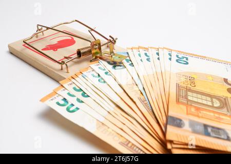 Euro banknotes in a mousetrap isolated on a white background, concept trapped by debts Stock Photo
