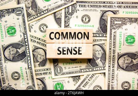 Common sense symbol. Concept words Common sense on beautiful wooden block. Beautiful background from dollar bills. Dollar bills. Business, motivationa Stock Photo