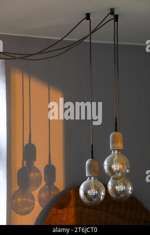 Modern interior lights. Minimalist house design. Three lightbulbs next to each other suspended in different heights Stock Photo