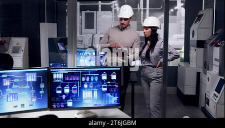 Factory Engineers In Helmets. Checking Industrial Facility Stock Photo