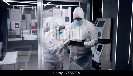 Sterile Semiconductor Manufacturing Factory And Workers In Coveralls Stock Photo