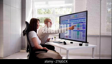 Analyst Employee Working On Spreadsheet Using Desktop Computer Stock Photo