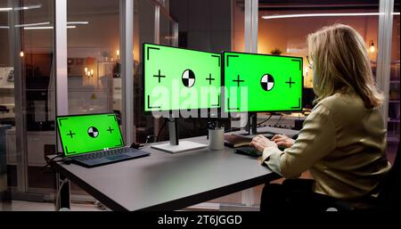 Woman Using Laptop on Office Desk with Computer Screen Stock Photo