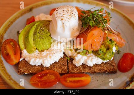 Cottage cheese, avocado, and smoked salmon cracker with poached egg on top Stock Photo