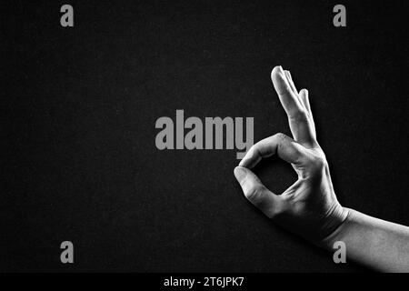 Hand Showing OK Good Sign in Black and White on Textured Paper Background, Copy Space Stock Photo