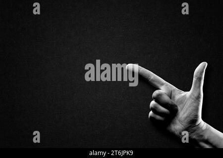 Hand Pointing Sign in Black and White on Textured Paper Background, Copy Space Stock Photo