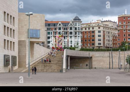 Bilbao Spain - 07 05 2021: View of tourists walking in downtown Bilbao, square with modern staircase, classic buildings in tourist area Stock Photo
