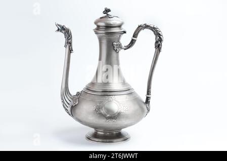 Vintage silver jug lamp teapot on a white background. Antique metal vessel with spout and handle side view. East tableware. Stock Photo