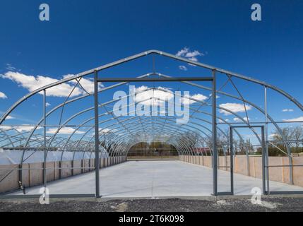 Steel frame greenhouse with newly poured concrete floor. Stock Photo