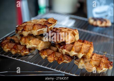 Eating of fresh baked hot Belgian sugar waffles, street food in Bruges, Brussels, Belgium Stock Photo