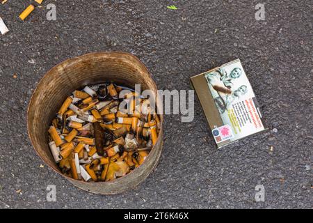 Discarded wet cigarette pack and butts in metal can ashtray, Quebec, Canada Stock Photo