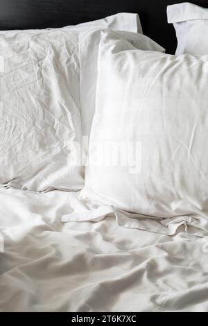 Empty wrinkled white bedding, close up. Stock Photo