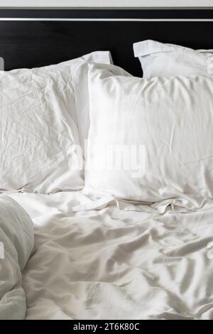 Empty wrinkled white bedding, close up. Stock Photo