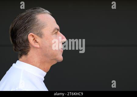 Side view portrait of a middle aged man with his mouth closed in front of a black wall Stock Photo