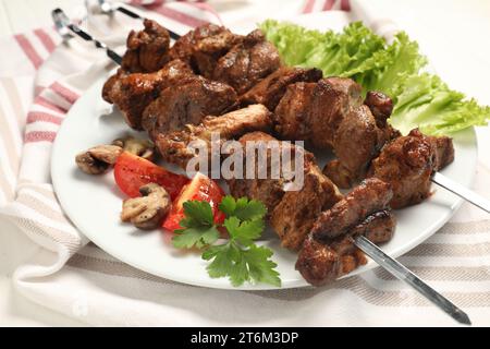 Delicious shish kebabs with vegetables on table Stock Photo