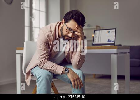 Stressed, tired, frustrated young business man is experiencing a burnout at work Stock Photo