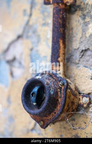 ancient old light switch rusted on crumbling concrete wall with cobwebs Stock Photo