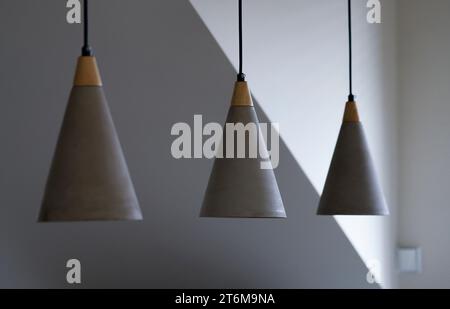 Concrete modern lights. Set of three grey minimalistic ceiling lights in the living room. Stock Photo