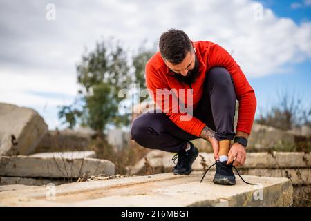 Young man is having pain in ankle while exercising outdoor. Stock Photo