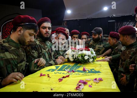 11 November 2023, Lebanon, Beirut: Pro-Iranian Hezbollah militants gather over the coffin of their colleague, who was killed along with six other comrades, in one of the party's largest death toll in one day, during his funeral procession in Beirut's southern suburbs. Since Hamas made a surprise attack on October 7th, more than 60 Hezbollah fighters have been killed. Photo: Marwan Naamani/dpa Stock Photo