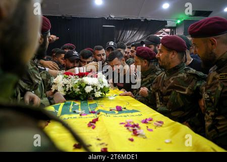 11 November 2023, Lebanon, Beirut: Pro-Iranian Hezbollah militants and relatives mourn over the coffin of their colleague, who was killed along with six other comrades, in one of the party's largest death toll in one day, during his funeral procession in Beirut's southern suburbs. Since Hamas made a surprise attack on October 7th, more than 60 Hezbollah fighters have been killed. Photo: Marwan Naamani/dpa Stock Photo