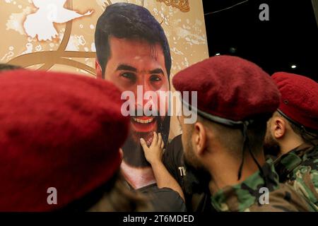 11 November 2023, Lebanon, Beirut: A Pro-Iranian Hezbollah militant touches the picture of his colleague, who was killed along with six other comrades, in one of the party's largest death tolls in one day, during his funeral procession in Beirut's southern suburb. Since Hamas made a surprise attack on October 7th, more than 60 Hezbollah fighters have been killed. Photo: Marwan Naamani/dpa Stock Photo