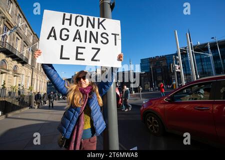 Edinburgh, Scotland, UK. 11th November, 2023. Anti Low Emission Zone ( LEZ) protesters hold up signs asking motorists to “honk against LEZ” in central Edinburgh today. The LEZ rules have already been controversially adopted in Glasgow and Edinburgh is due to introduce a similar scheme in the city centre.   Iain Masterton/Alamy Live News Stock Photo