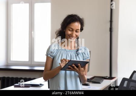 Happy pretty gadget user woman in casual using professional app Stock Photo