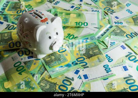 Money pig on the background of money bills of 100 euros, left angle view on piggy bank with shadow. High quality photo Stock Photo