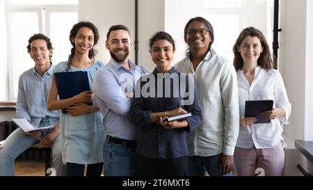 Multiethnic confident group of happy employees holding notebooks Stock Photo