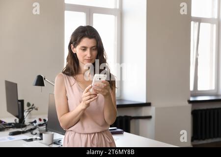 Focused serious young office worker woman using online app Stock Photo