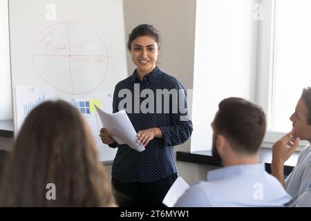 Happy confident Indian businesswoman presenting project to colleagues Stock Photo