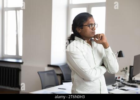 Thoughtful serious Indian business man in casual glasses standing Stock Photo